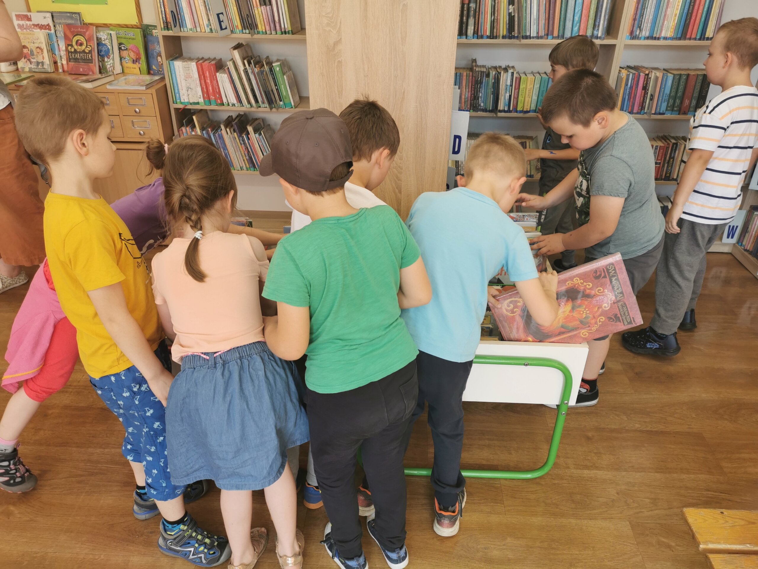 Dzieci oglądają książki w bibliotece