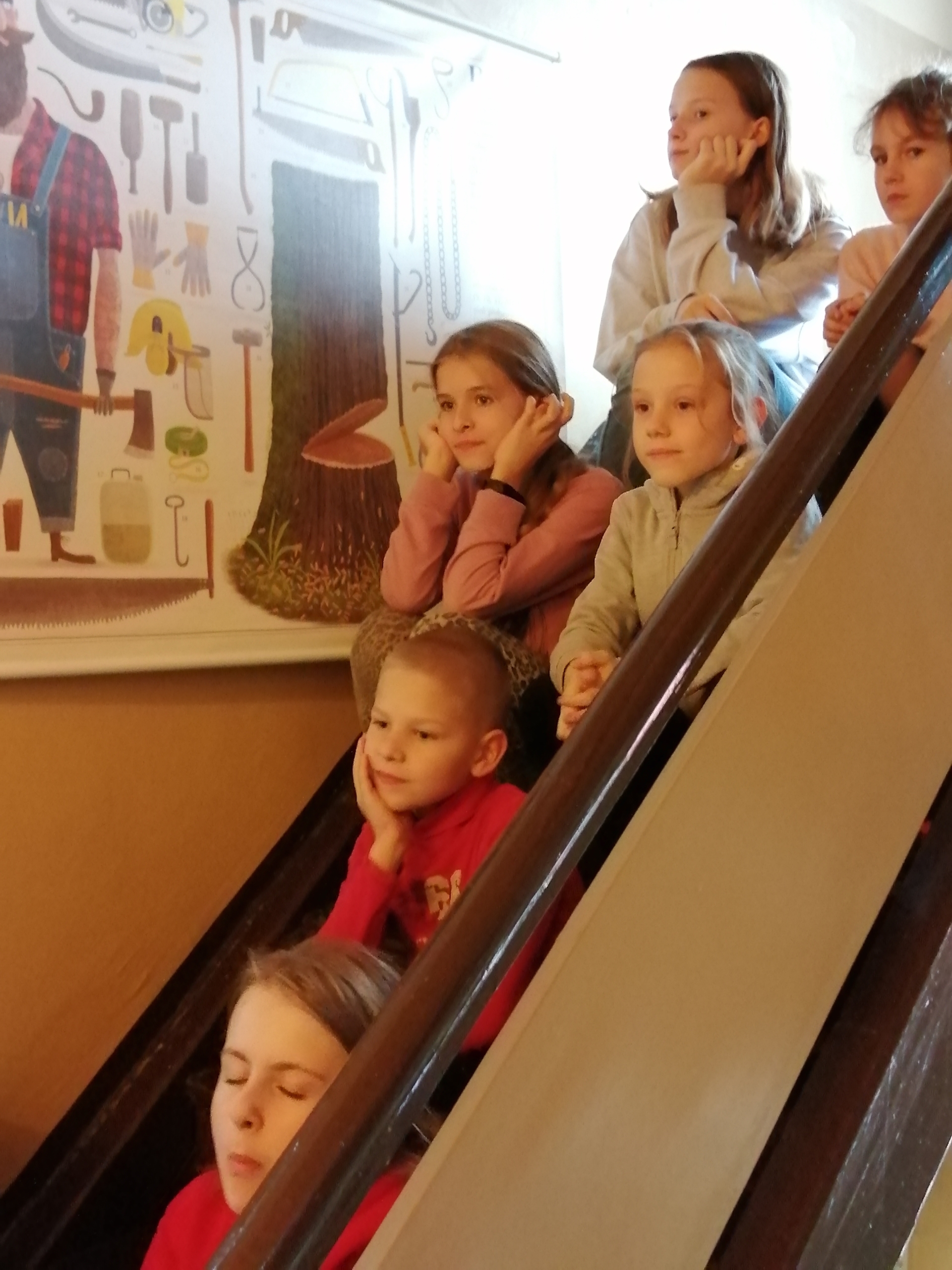 Zasłuchane dzieci siedzące na schodach