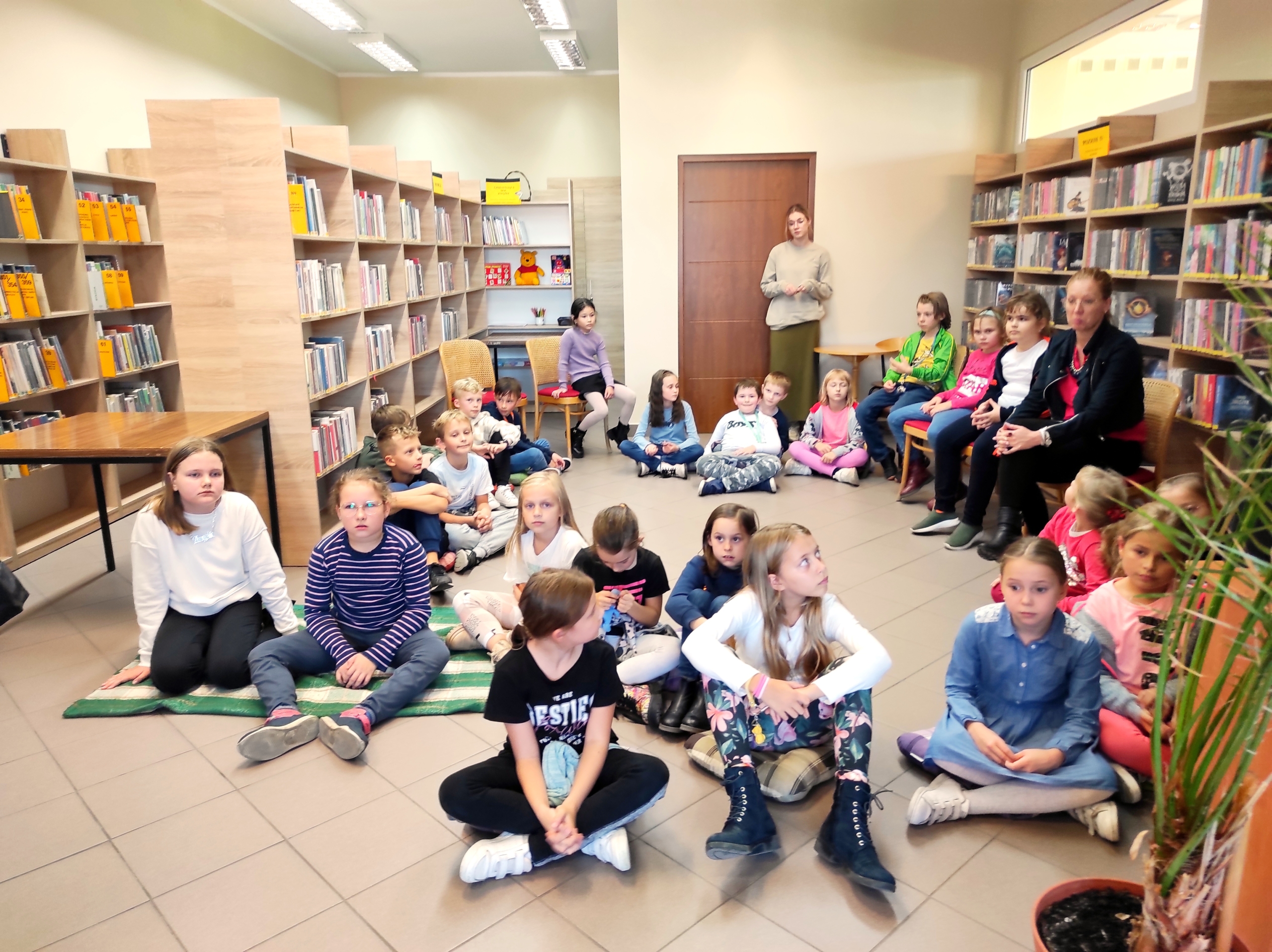 Uczniowie słuchający bibliotekarki