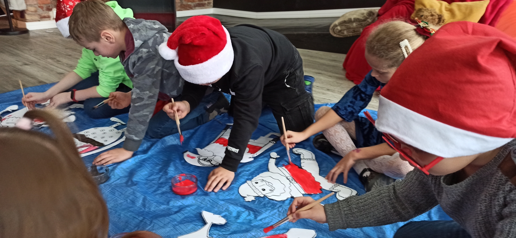 Dzieci malujące papierowe Mikołaje
