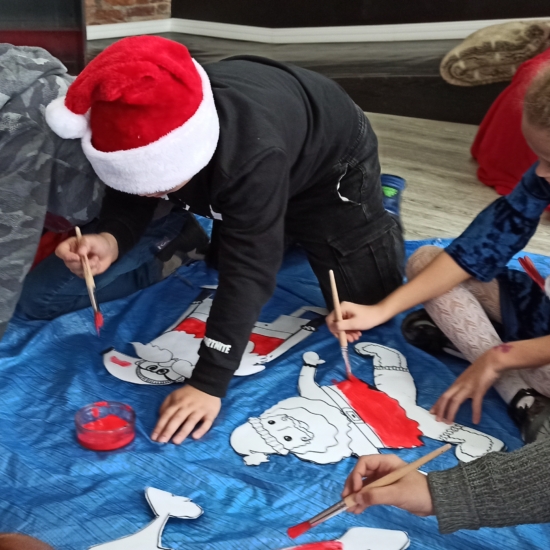 Dzieci malujące papierowe Mikołaje