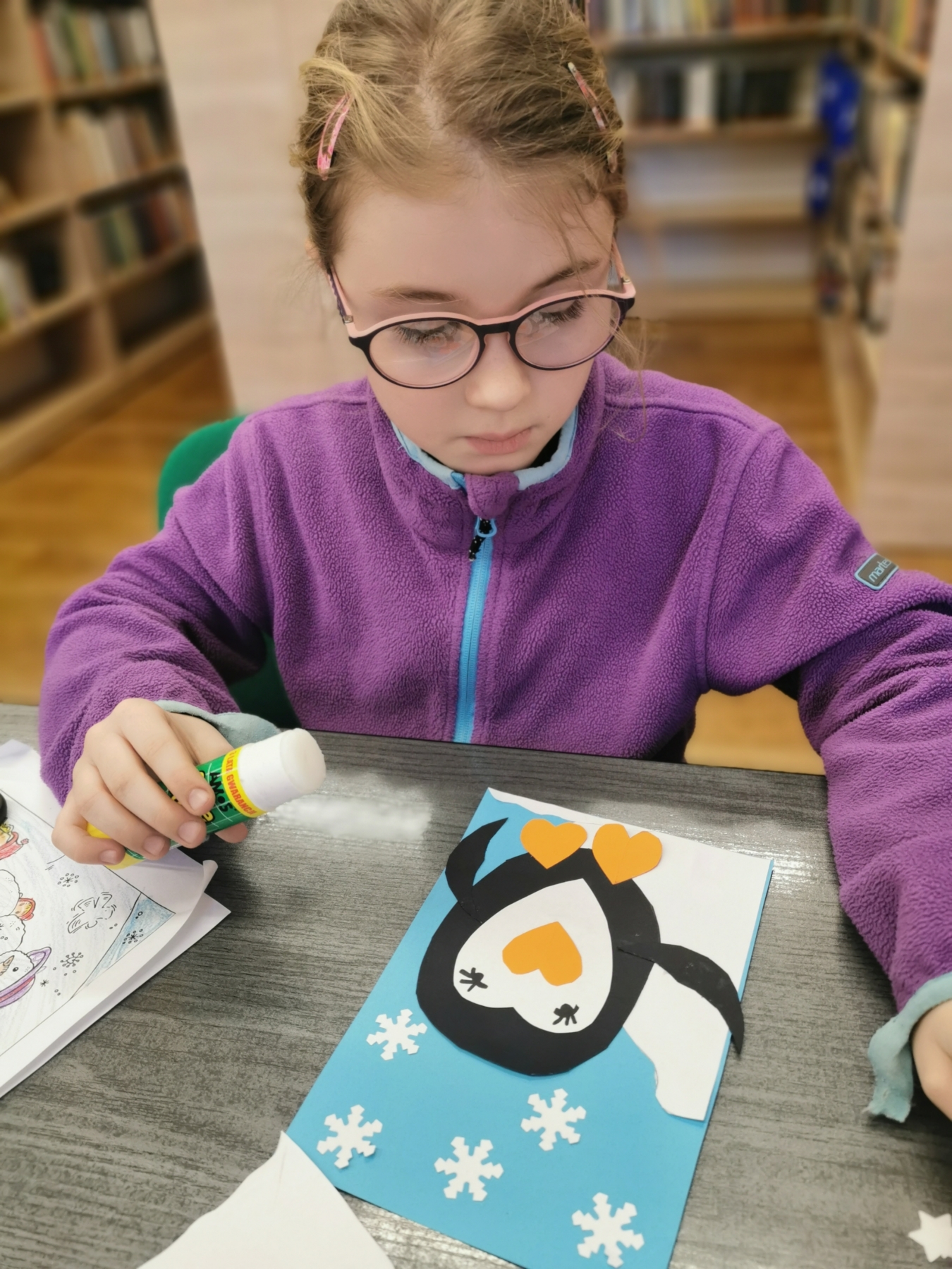 Dziewczynka wykonująca pracę plastyczna z pingwinem