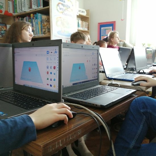 Młodzież przy laptopach projektuje breloczki 3D