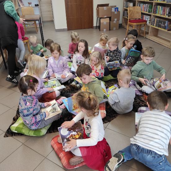 Przedszkolaki w bibliotece oglądają książki