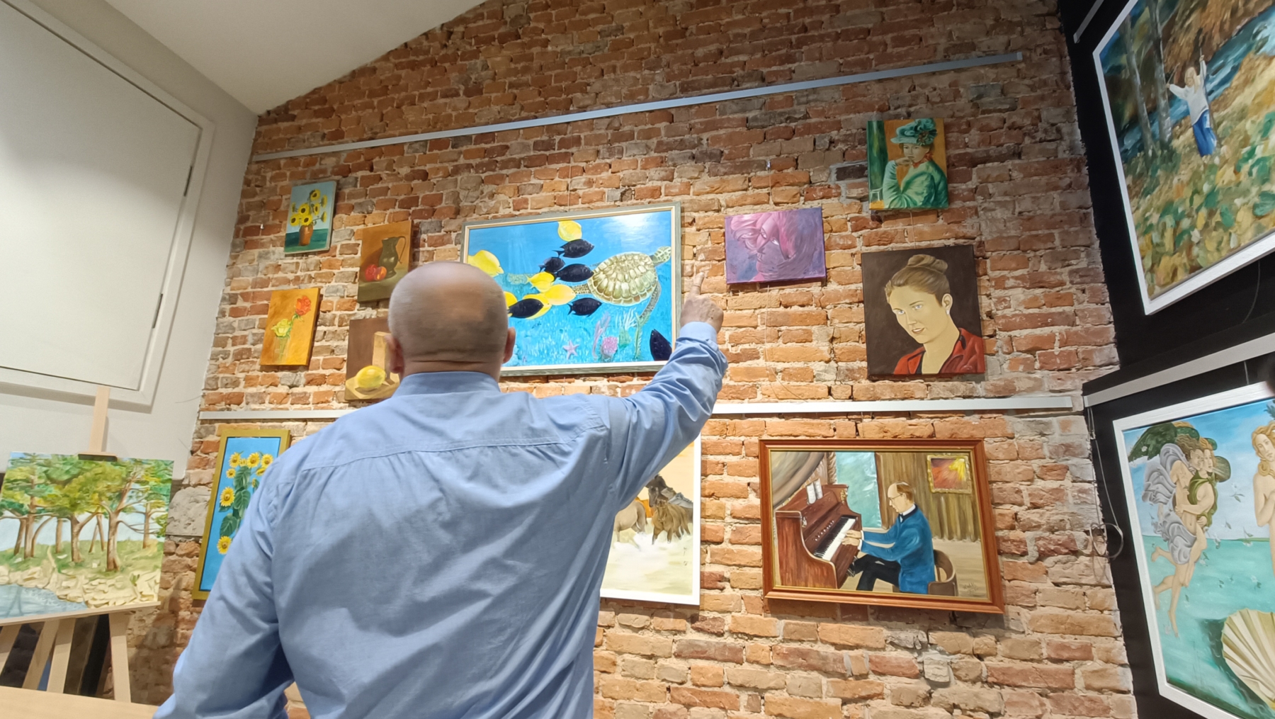 Henryk Kulik pokazujący swoje obrazy