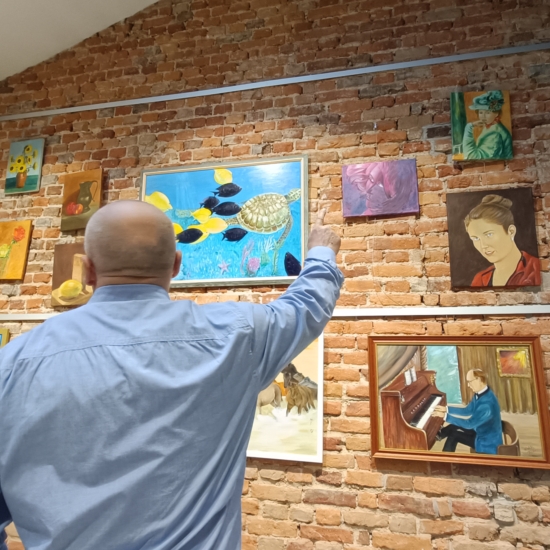 Henryk Kulik pokazujący swoje obrazy