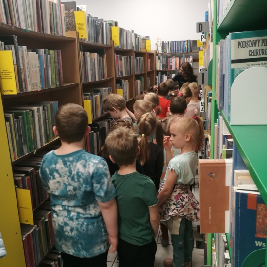 Dzieci między regałami w bibliotece