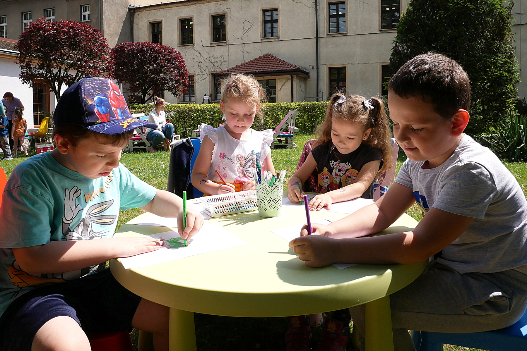Dzieci rysujące w ogrodzie biblioteki