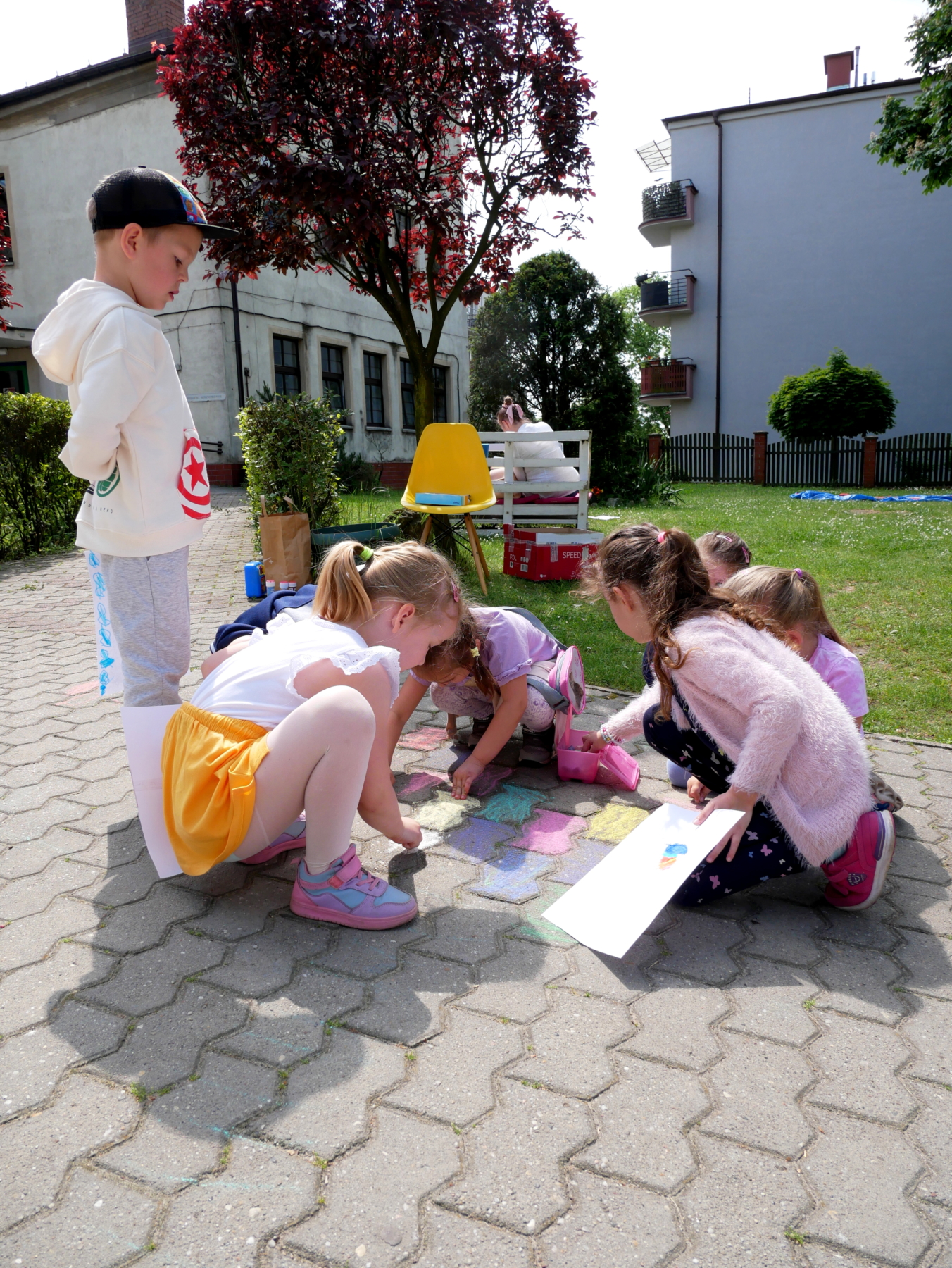 Dzieci rysujące kredą na chodniku