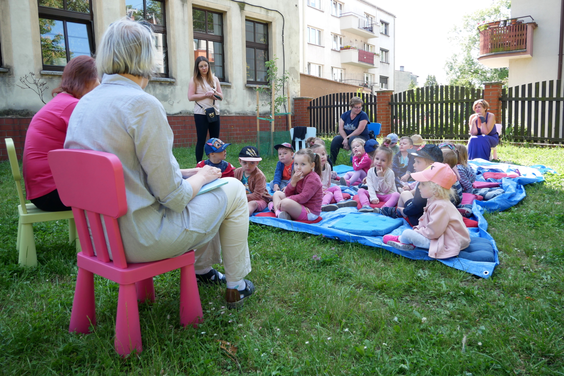  Dzieci siedzące na poduszkach i słuchające bibliotekarek
