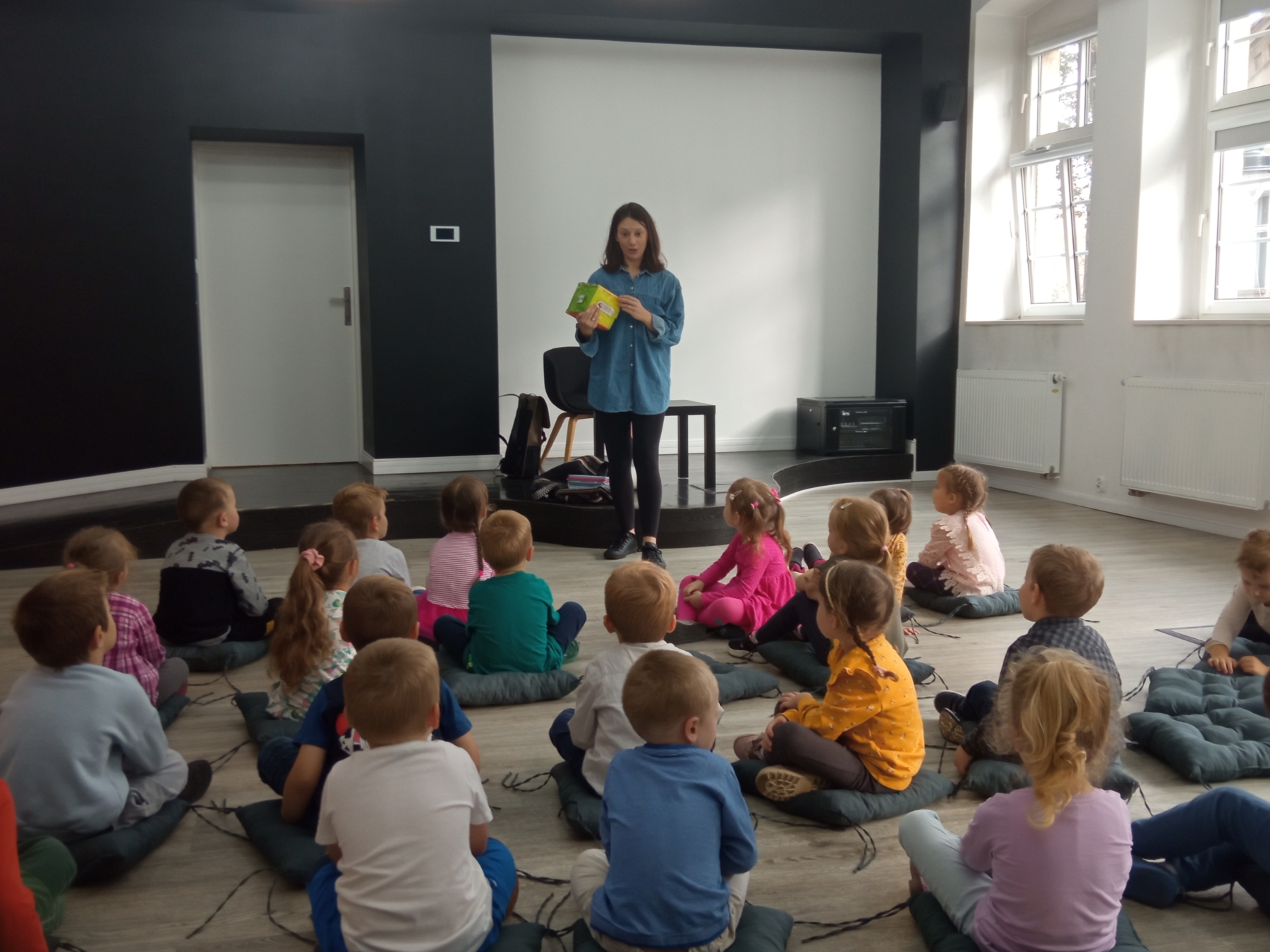 Barbara Supeł, autorka, pokazuje dzieciom książeczkę