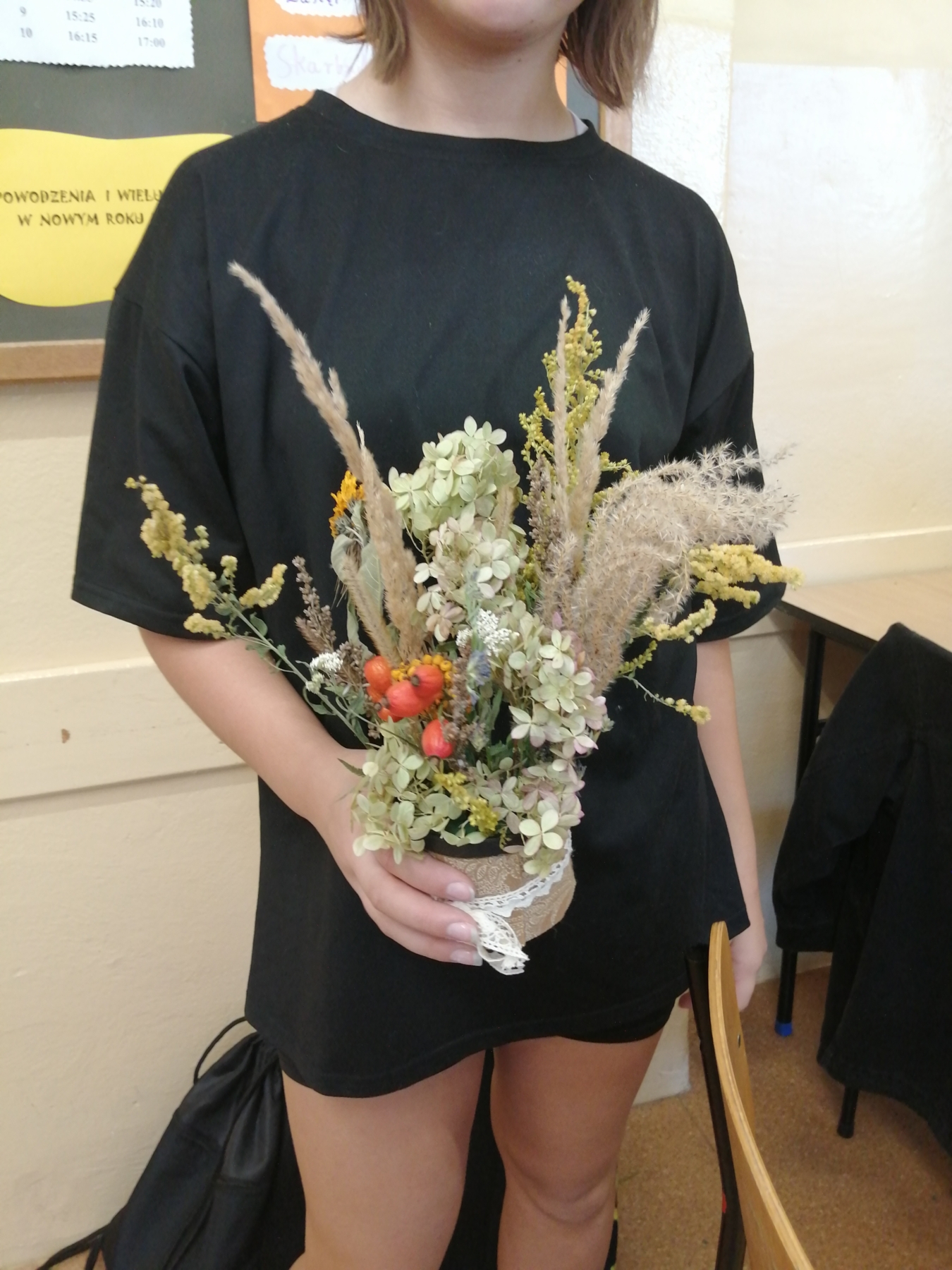 Uczennica prezentuje wykonaną przez siebie kwiatową kompozycję