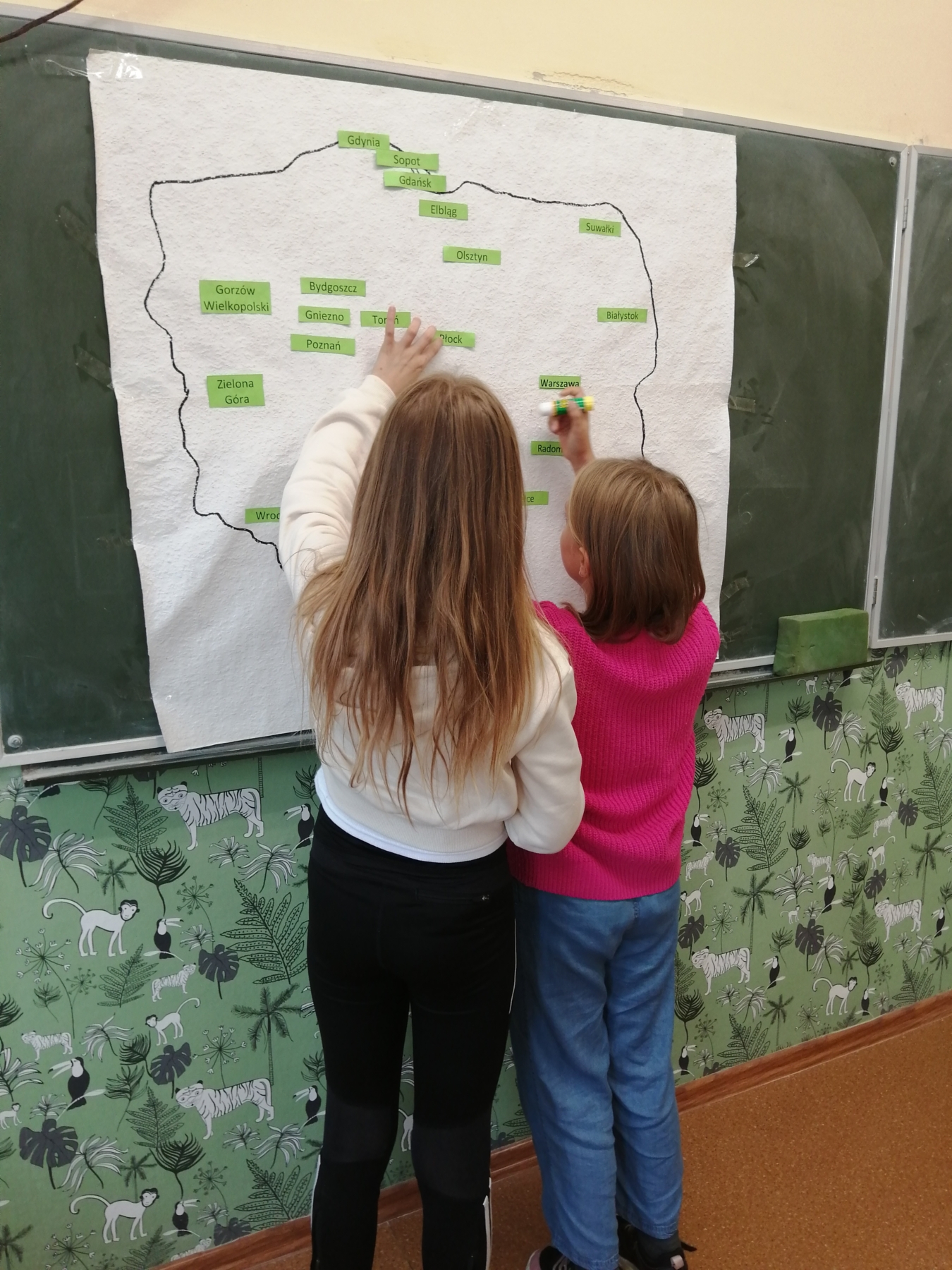 Uczniowie umieszczają nazwy miast na mapie Polski