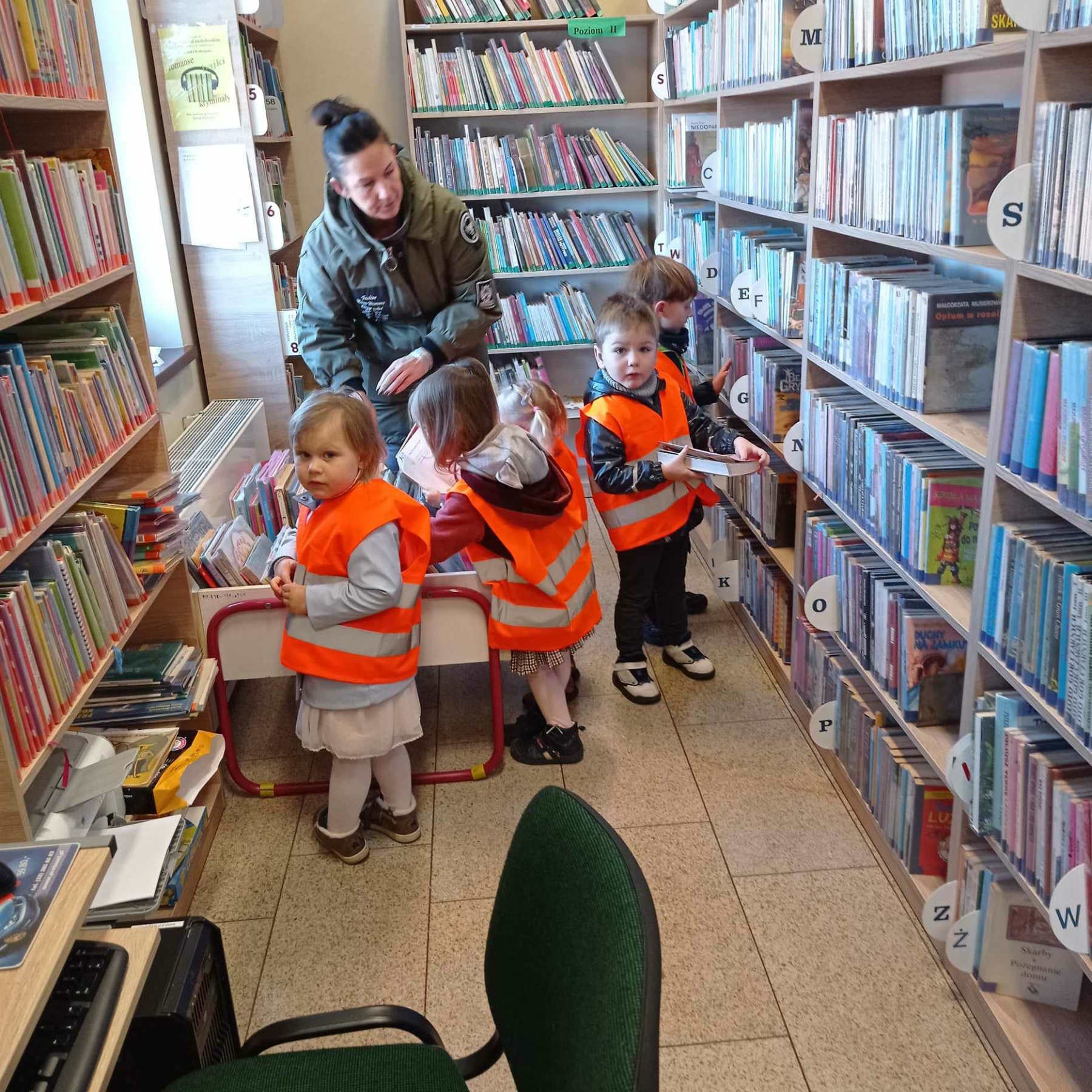 Dzieci przeglądają książki na regałach