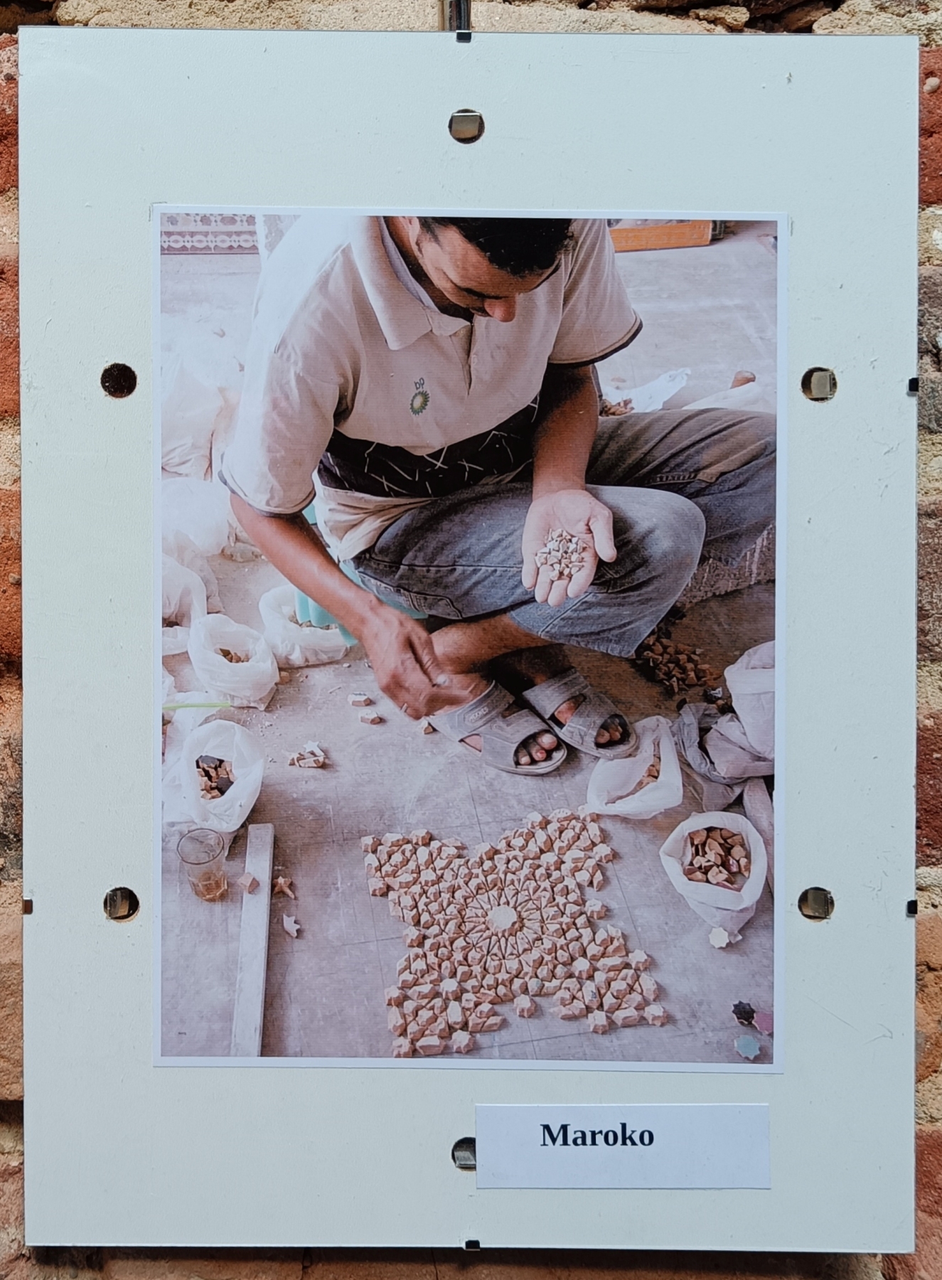 Fotografia przedstawiająca mężczyznę układającego wzór z kamieni