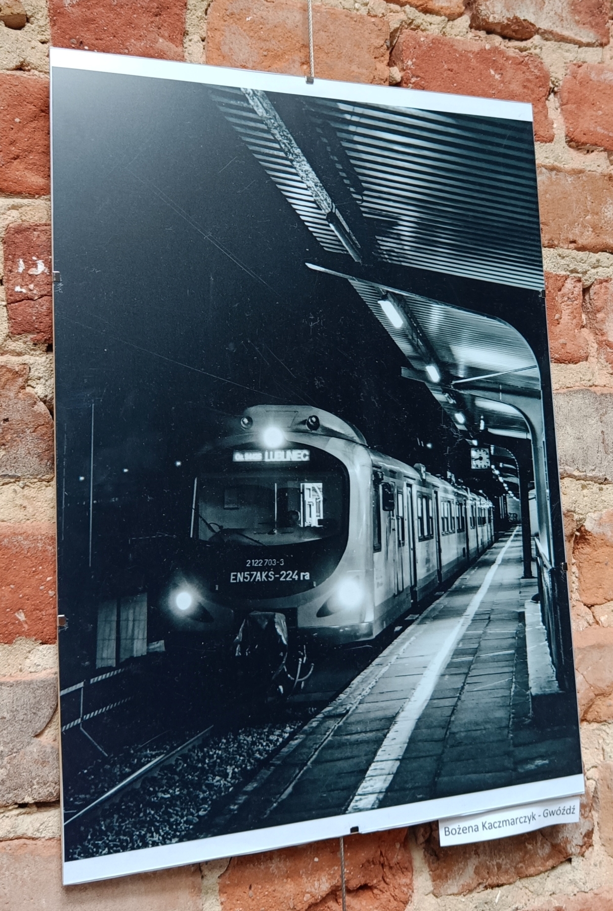 Zdjęcia wiszą na ceglanej ścianie pociąg stojący na stacji