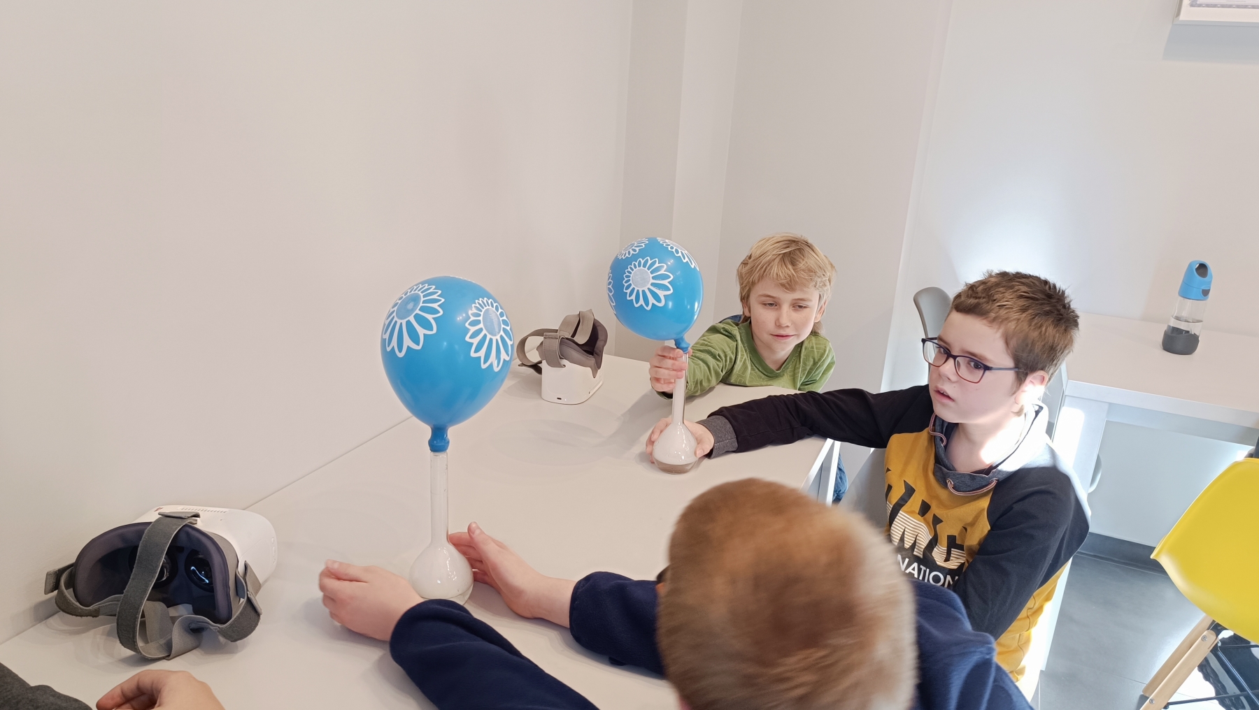 Dzieci patrzą na eksepryment z nadmuchiwaniem balonów