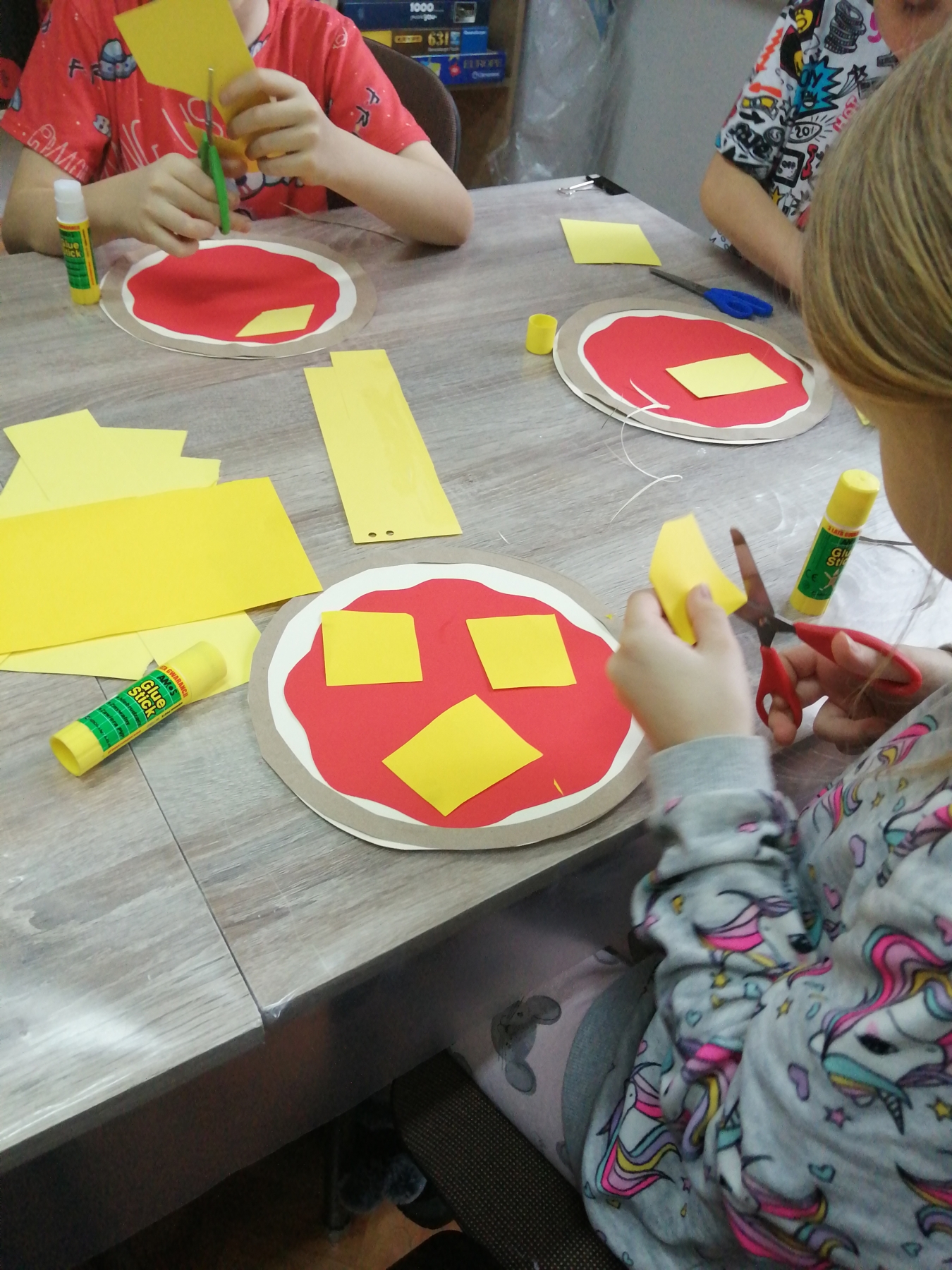 Dzieci wykonują papierowe pizze