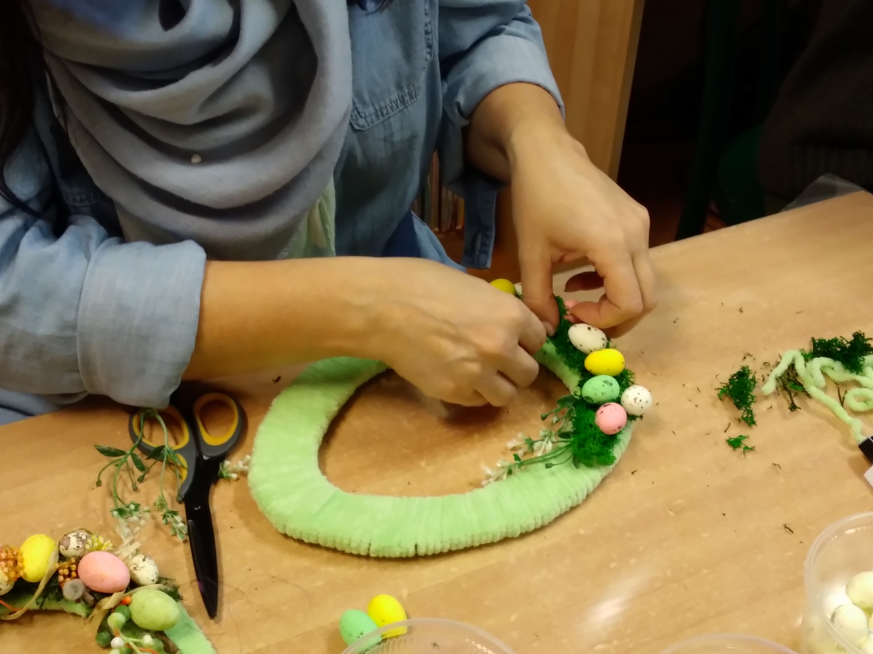 Uczestniczka warsztatów wykonuje dekoracyjne jajko