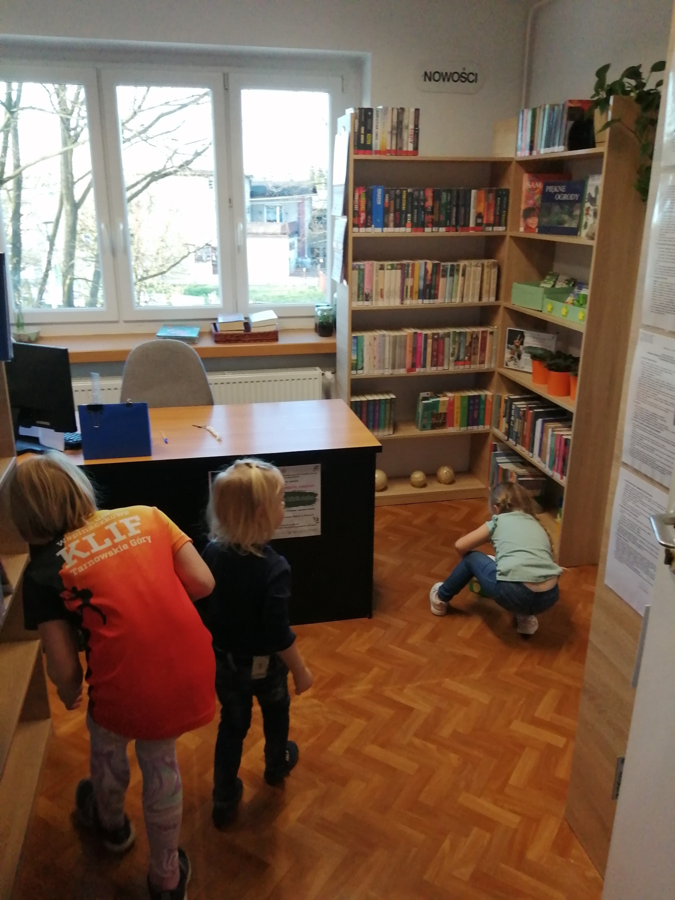 Dzieci szukają w bibliotece schowanych jajeczek