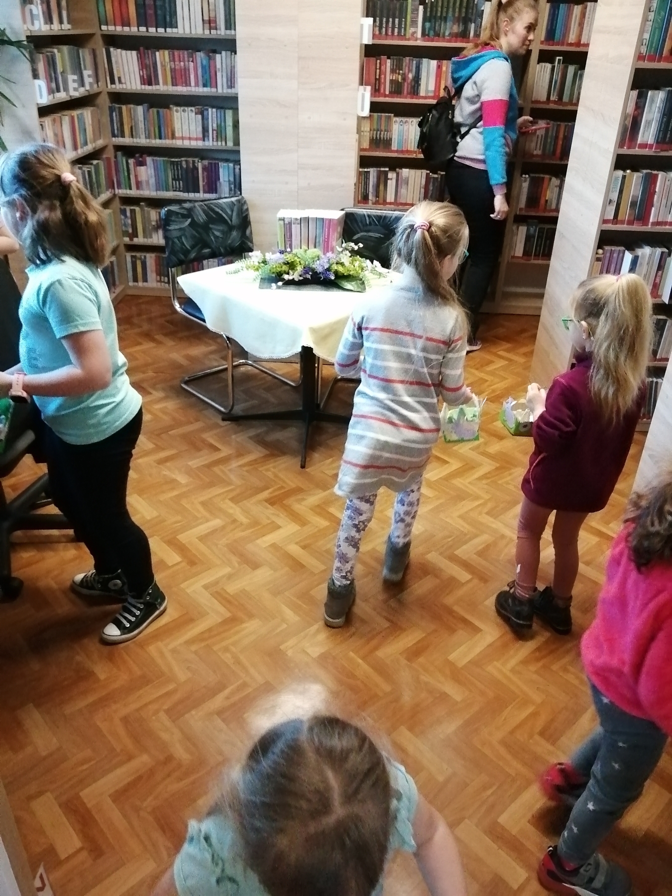 Dzieci szukają w bibliotece schowanych jajeczek