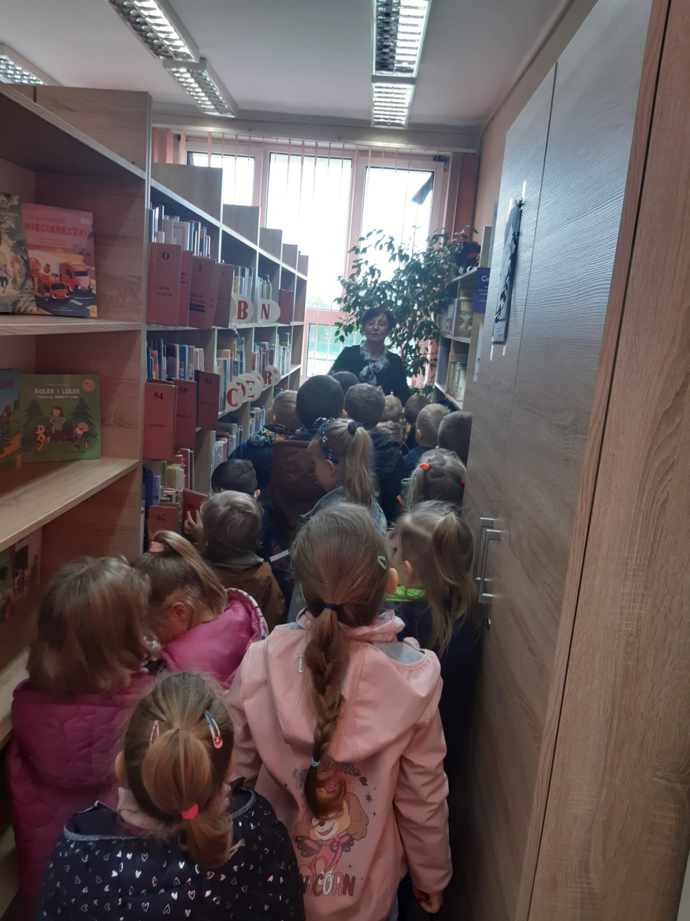 Dzieci oglądają książki na regałach