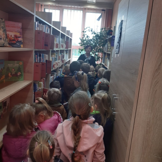 Dzieci oglądają książki na regałach